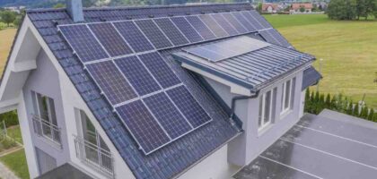 Solar panels installed on the roof of a modern house surrounded by countryside views.
