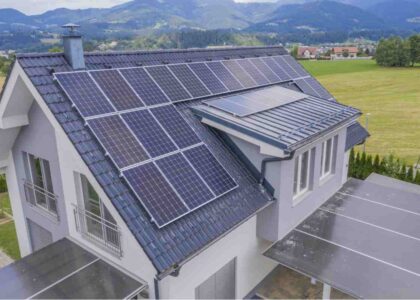 Solar panels installed on the roof of a modern house surrounded by countryside views.